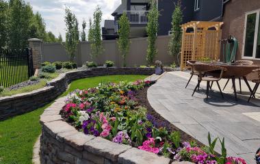Tiered yard with patio and rock walls made this once sloped yard into a beautiful garden