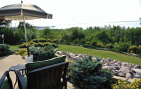 Cottage Landscaping with a view of the lake.  Rock Walls and Shrubs surrounds the yard.